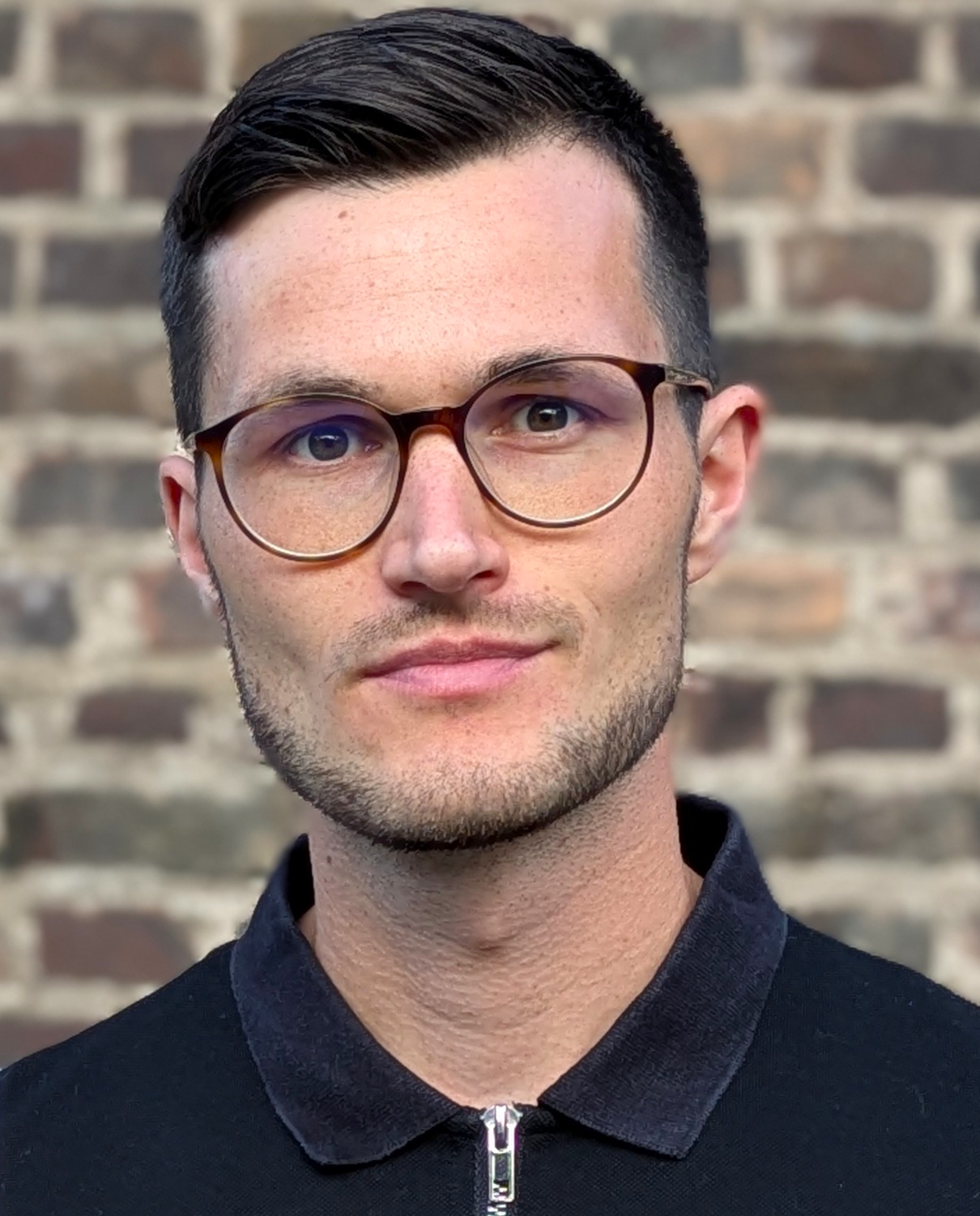 Foto von Tobias Kreutzer vor einer Backsteinwand